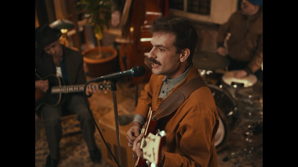 James McClaskey singing and playing guitar with the Rhythm Band.